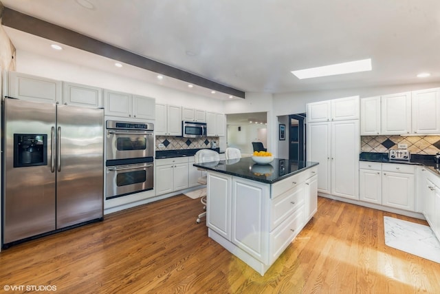 37782 N Cedar Lake Rd, Lake Villa, IL 60046 - kitchen featuring appliances with stainless steel finishes, a skylight, decorative backsplash, a center island, and recessed lighting