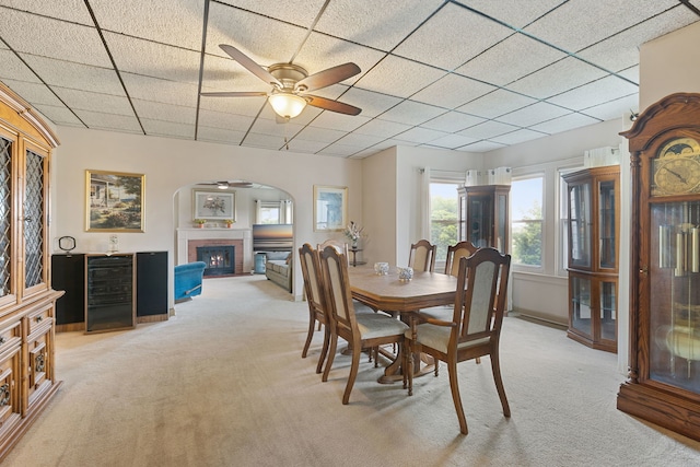 30W311 W Bartlett Rd, Bartlett, IL 60103 - dining area featuring ceiling fan, light colored carpet, a fireplace, arched walkways, and a paneled ceiling