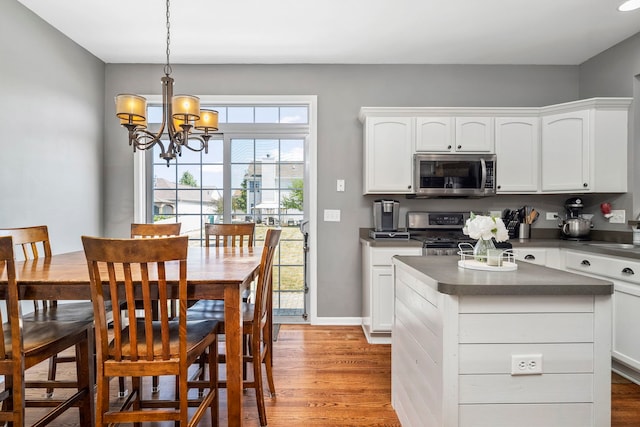 1014 Bayside Ln, Shorewood, IL 60404 - kitchen featuring stainless steel appliances, dark countertops, a chandelier, and light wood-style floors