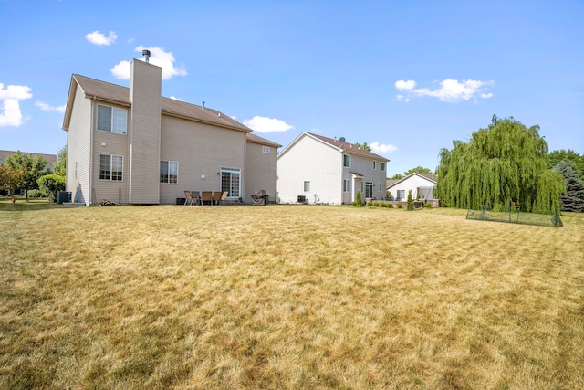 1014 Bayside Ln, Shorewood, IL 60404 - rear view of property with a chimney, a lawn, and central AC unit