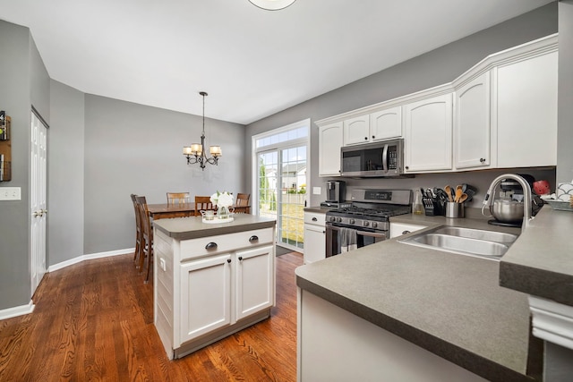 1014 Bayside Ln, Shorewood, IL 60404 - kitchen featuring appliances with stainless steel finishes, a sink, dark wood-style floors, white cabinetry, and a chandelier