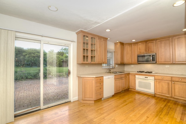 6N002 Laurel Dr, Medinah, IL 60157 - kitchen with white appliances, a sink, light wood-type flooring, light countertops, and glass insert cabinets
