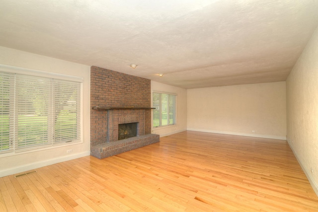 6N002 Laurel Dr, Medinah, IL 60157 - unfurnished living room with light wood-style flooring, baseboards, and a fireplace