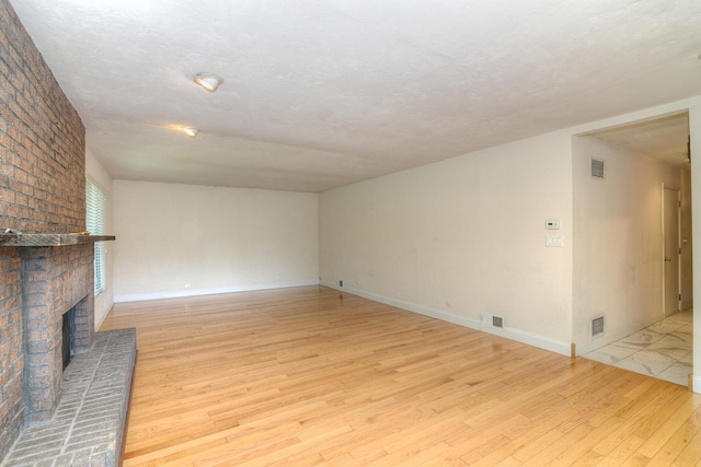 6N002 Laurel Dr, Medinah, IL 60157 - unfurnished living room featuring light wood-type flooring, a brick fireplace, and baseboards