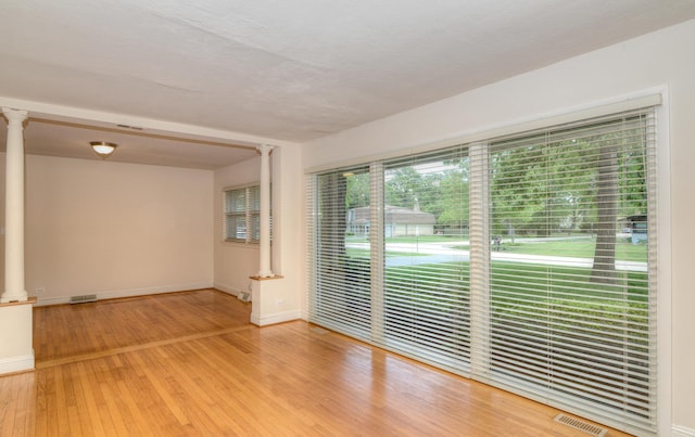 6N002 Laurel Dr, Medinah, IL 60157 - unfurnished room featuring ornate columns, baseboards, and wood finished floors