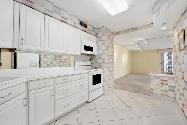 6033 N Sheridan Rd Unit 8E, Chicago, IL 60660 - kitchen featuring white appliances, open floor plan, white cabinetry, light countertops, and wallpapered walls
