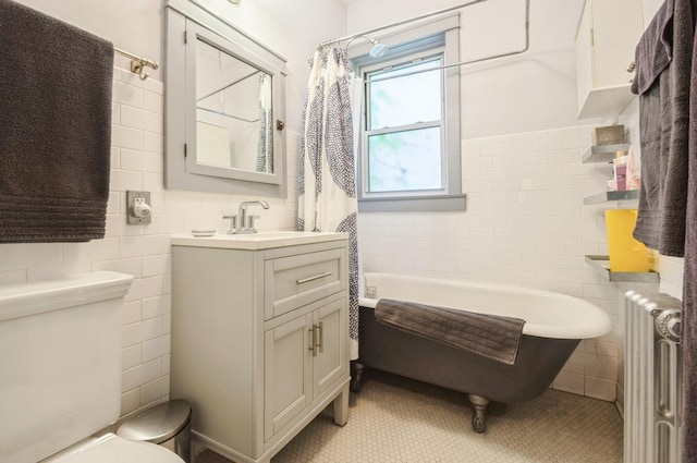 1458 W Argyle St Unit 1N, Chicago, IL 60640 - bathroom with radiator heating unit, tile walls, toilet, a soaking tub, and vanity