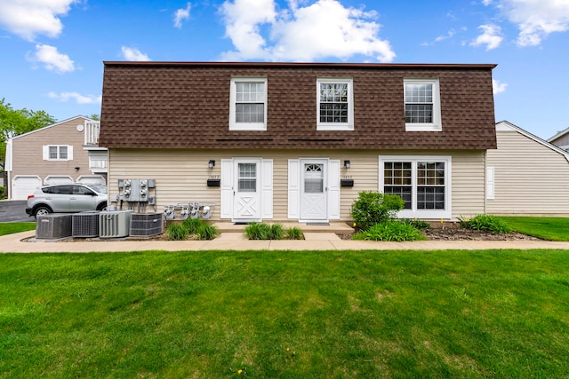 1585 Woodcutter Ln Unit D, Wheaton, IL 60189 - back of property featuring a shingled roof, mansard roof, a lawn, and central AC