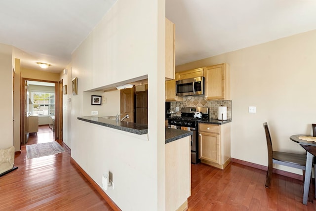 1585 Woodcutter Ln Unit D, Wheaton, IL 60189 - kitchen with stainless steel appliances, light brown cabinetry, dark countertops, and hardwood / wood-style floors