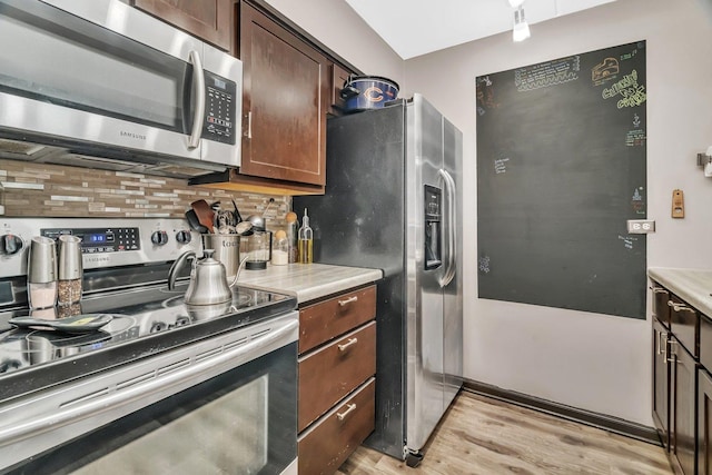 14028 Laramie Ave Unit 1719, Crestwood, IL 60418 - kitchen featuring appliances with stainless steel finishes, decorative backsplash, light wood-style floors, and light countertops