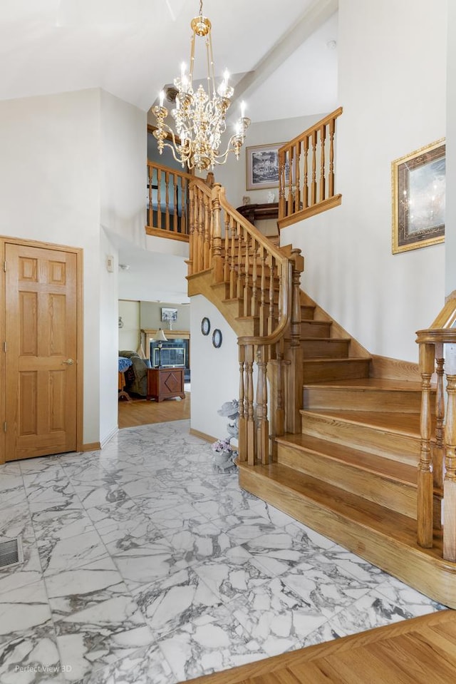 13836 W Joliet Rd, Manhattan, IL 60442 - stairs featuring a towering ceiling, marble look tiles, a chandelier, and baseboards