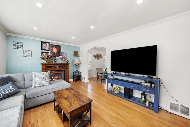 9141 S Albany Ave S, Evergreen Park, IL 60805 - living room featuring arched walkways, crown molding, light wood-style floors, recessed lighting, and a warm lit fireplace