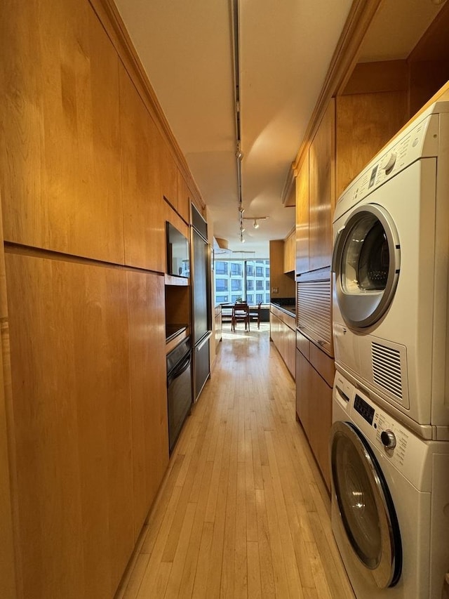 155 N Harbor Dr Unit 1103, Chicago, IL 60601 - kitchen with stacked washer / drying machine, rail lighting, light wood-style flooring, built in fridge, and brown cabinets