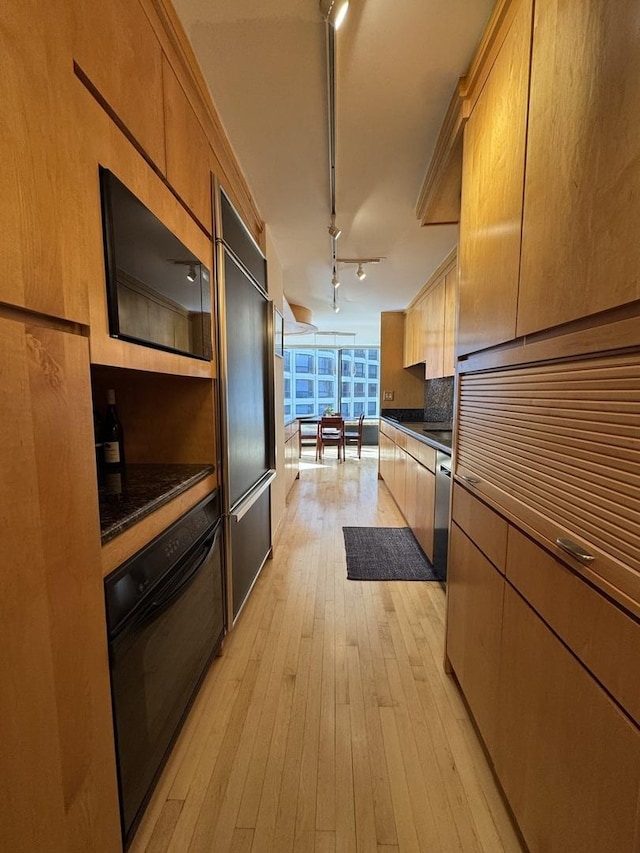 155 N Harbor Dr Unit 1103, Chicago, IL 60601 - kitchen with black oven, dark countertops, light wood finished floors, tasteful backsplash, and rail lighting