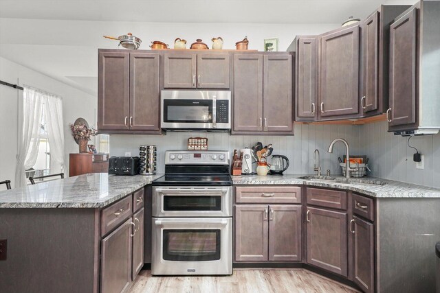 6010 Peart Rd, Morris, IL 60450 - kitchen with appliances with stainless steel finishes, a peninsula, light wood-style floors, and light stone countertops
