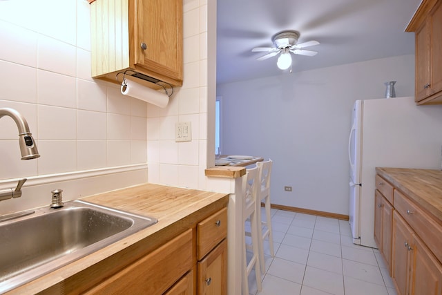 5816 N Nagle Ave Unit B, Chicago, IL 60646 - kitchen with a sink, ceiling fan, light tile patterned floors, backsplash, and freestanding refrigerator