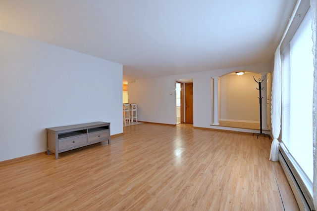 5816 N Nagle Ave Unit B, Chicago, IL 60646 - unfurnished living room with baseboard heating, plenty of natural light, light wood-style floors, and arched walkways