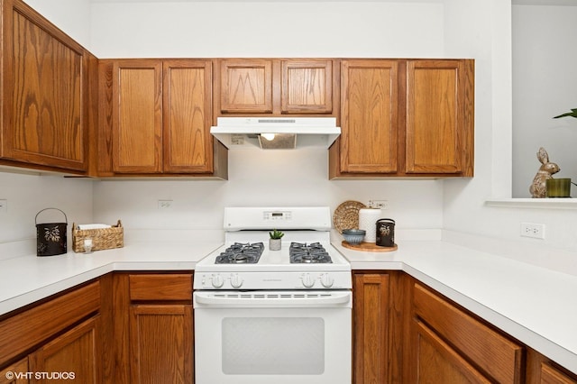 707 Morris Ct, Lakemoor, IL 60051 - kitchen featuring under cabinet range hood, gas range gas stove, light countertops, and brown cabinets