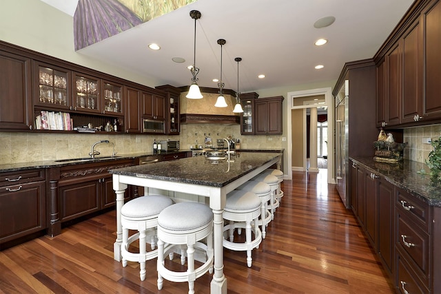 26285 W Roberts Ln, Barrington, IL 60010 - kitchen with a sink, a kitchen breakfast bar, tasteful backsplash, dark brown cabinets, and recessed lighting