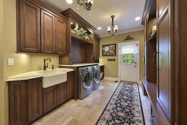 26285 W Roberts Ln, Barrington, IL 60010 - laundry room featuring cabinet space, a chandelier, ornamental molding, washing machine and clothes dryer, and stone tile flooring