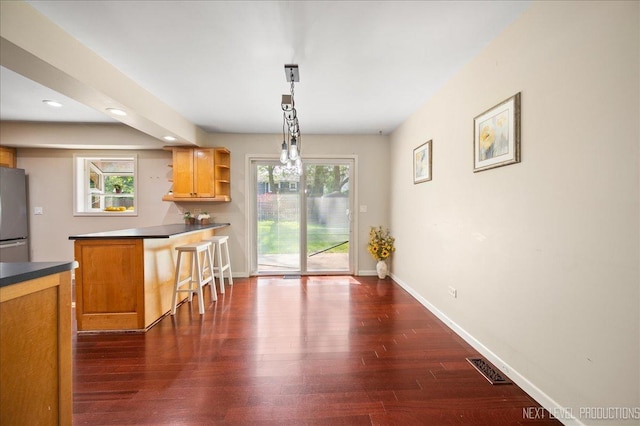 6416 W Rawson Bridge Rd W, Cary, IL 60013 - kitchen featuring a breakfast bar area, open shelves, freestanding refrigerator, baseboards, and dark wood-style floors