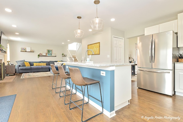 411 Lake Plumleigh Way, Algonquin, IL 60102 - kitchen with freestanding refrigerator, light wood-style floors, white cabinets, a breakfast bar area, and recessed lighting