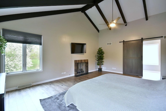 179 Old Forge Rd, Elgin, IL 60123 - bedroom with beamed ceiling, a brick fireplace, a barn door, wood finished floors, and baseboards