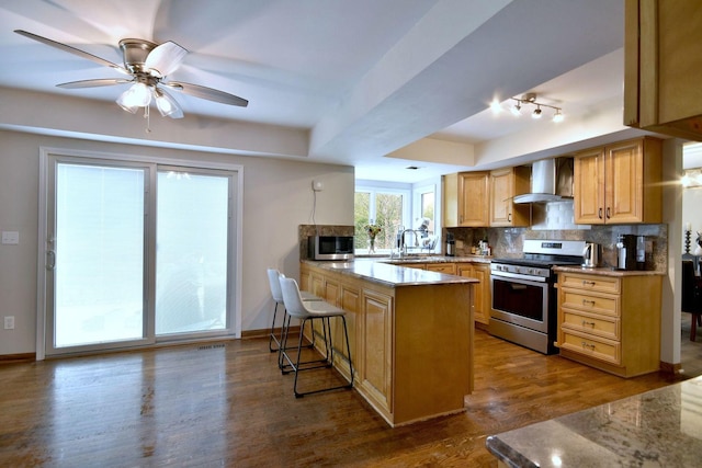 179 Old Forge Rd, Elgin, IL 60123 - kitchen with wall chimney exhaust hood, stainless steel appliances, a sink, a peninsula, and tasteful backsplash