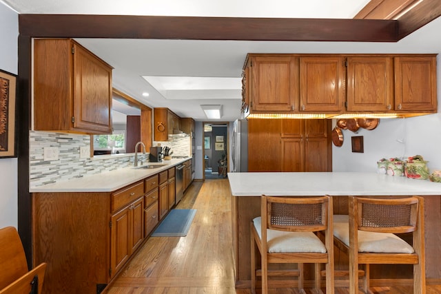 22W300 Arbor Ln, Glen Ellyn, IL 60137 - kitchen with appliances with stainless steel finishes, a sink, light wood-style flooring, a peninsula, and brown cabinets
