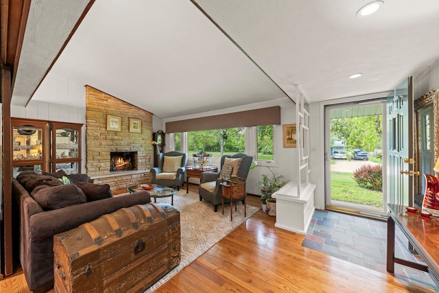 22W300 Arbor Ln, Glen Ellyn, IL 60137 - living room featuring plenty of natural light, light wood-type flooring, a stone fireplace, vaulted ceiling, and recessed lighting