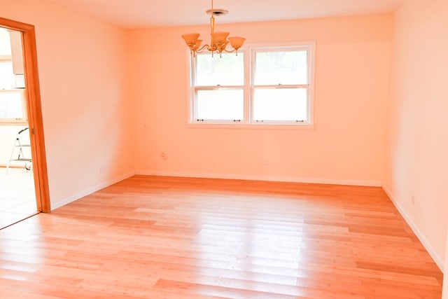 17315 Bryant Ln, Hazel Crest, IL 60429 - spare room with a chandelier, light wood-style flooring, and baseboards