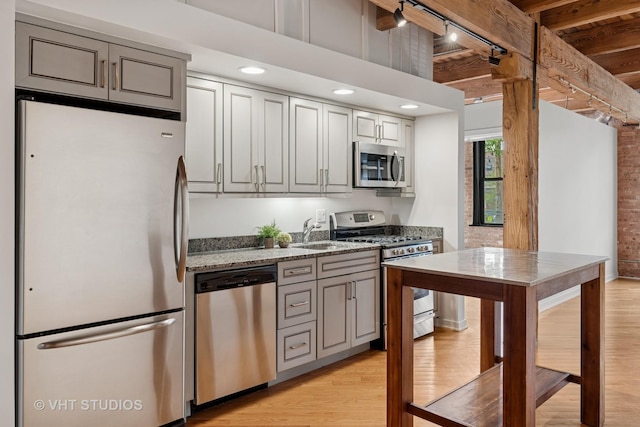 3201 N Ravenswood Ave Unit 203, Chicago, IL 60657 - kitchen featuring appliances with stainless steel finishes, a sink, light wood finished floors, light stone counters, and gray cabinets
