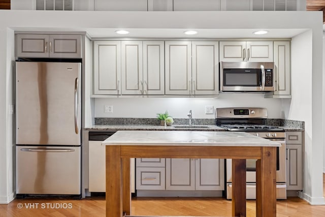 3201 N Ravenswood Ave Unit 203, Chicago, IL 60657 - kitchen featuring appliances with stainless steel finishes, a sink, light stone countertops, gray cabinets, and recessed lighting