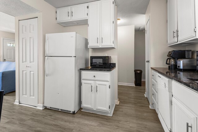 610 English Creek Ct Unit B, Champaign, IL 61821 - kitchen featuring white appliances, white cabinetry, light wood finished floors, dark stone countertops, and a textured ceiling