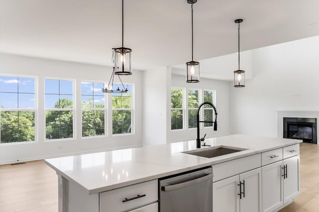 28 Open Pkwy, Hawthorn Woods, IL 60047 - kitchen with stainless steel dishwasher, a sink, open floor plan, light wood-style flooring, and white cabinetry