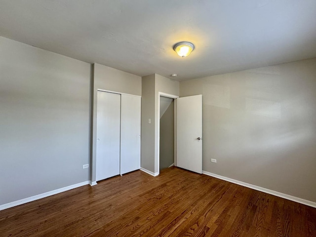 14401 Kolin Ave, Midlothian, IL 60445 - unfurnished bedroom with wood finished floors, baseboards, and a closet