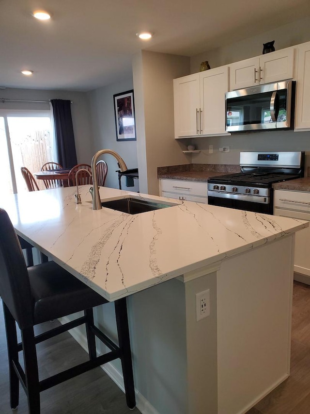 754 Westbury Dr, Cary, IL 60013 - kitchen with appliances with stainless steel finishes, a center island with sink, a breakfast bar area, dark wood-style flooring, and recessed lighting