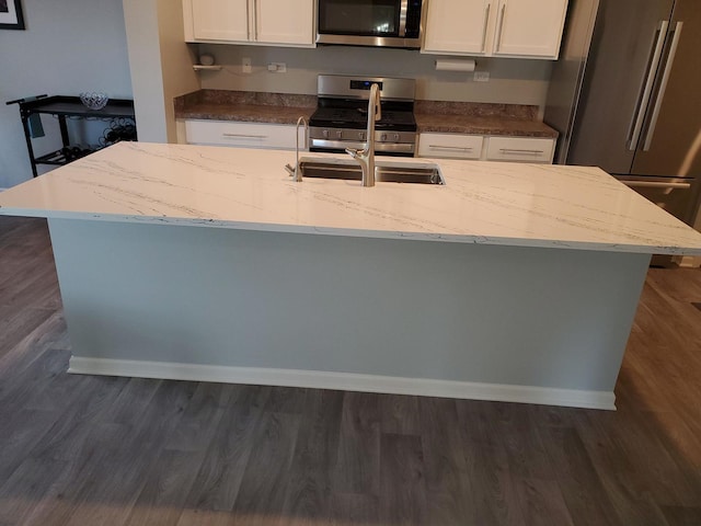 754 Westbury Dr, Cary, IL 60013 - kitchen featuring appliances with stainless steel finishes, white cabinetry, a kitchen island with sink, and light stone counters