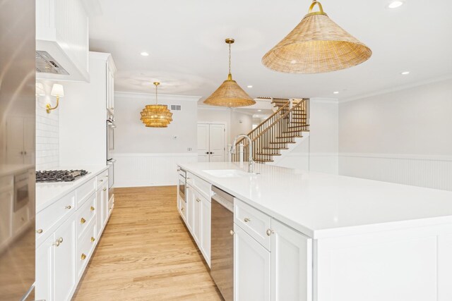 6202 Flagg Creek Ln, Western Springs, IL 60558 - kitchen featuring a sink, stainless steel appliances, wainscoting, light wood-style floors, and white cabinets