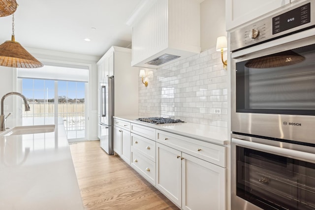 6202 Flagg Creek Ln, Western Springs, IL 60558 - kitchen featuring appliances with stainless steel finishes, a sink, white cabinets, light countertops, and tasteful backsplash