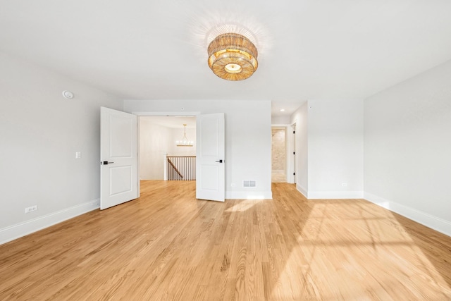 6202 Flagg Creek Ln, Western Springs, IL 60558 - empty room with a chandelier, baseboards, and light wood-style flooring