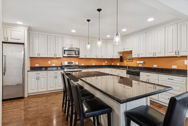 512 N Rose Ave, Park Ridge, IL 60068 - kitchen with appliances with stainless steel finishes, white cabinets, dark wood-type flooring, a breakfast bar area, and recessed lighting