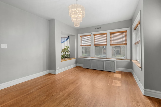 7744 S Laflin St, Chicago, IL 60620 - unfurnished room with radiator heating unit, light wood-type flooring, a chandelier, and baseboards