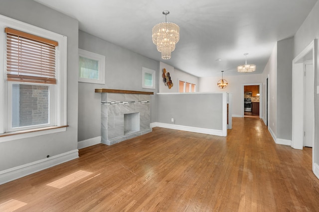 7744 S Laflin St, Chicago, IL 60620 - unfurnished living room featuring a chandelier, wood finished floors, baseboards, and plenty of natural light