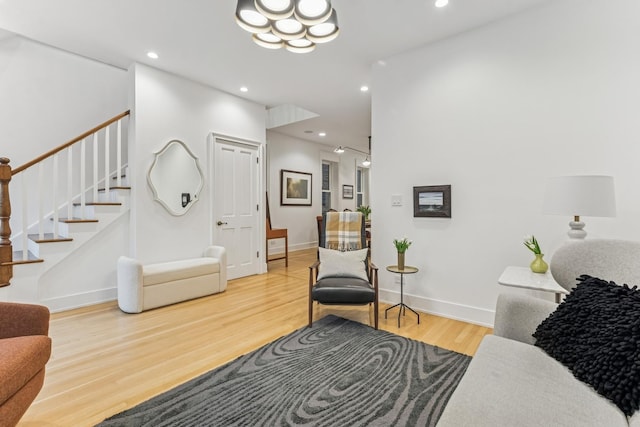 living room featuring stairs, wood finished floors, recessed lighting, and a chandelier