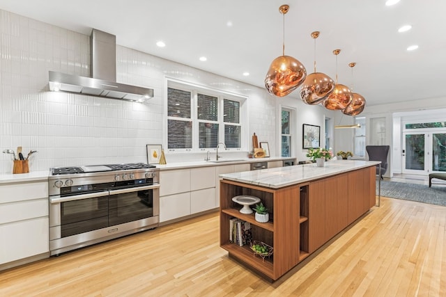 kitchen with range with two ovens, wall chimney range hood, open shelves, modern cabinets, and light wood-style floors