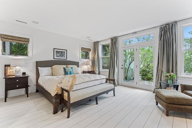 bedroom with access to exterior and light wood-style floors