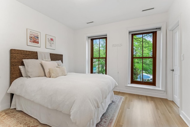 bedroom with light wood finished floors and baseboards