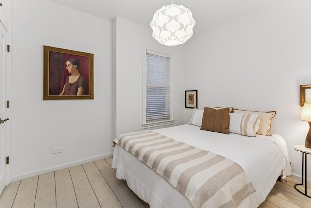 bedroom featuring baseboards and wood finished floors