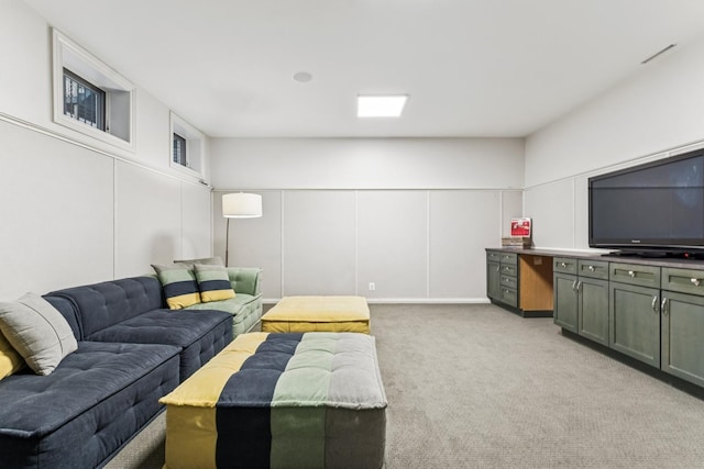 living area featuring a decorative wall and light carpet